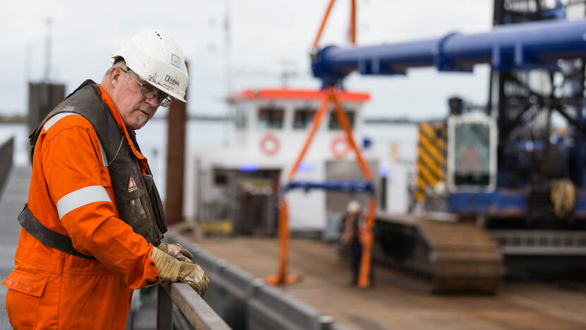 De aannemer kijkt toe op het werk bij de Krammersluizen